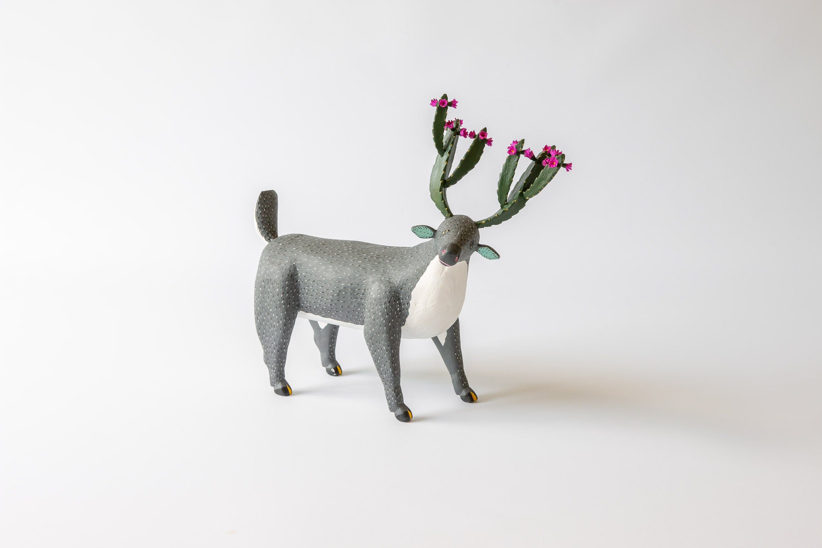 A deer with cactus antlers and a grey fur.